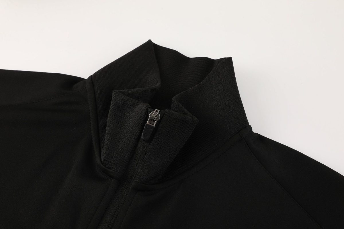 Close-up of a black jacket collar with a metal zipper pull visible