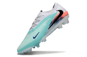 Nike running shoe in light turquoise with blue swoosh, white sole, and orange-to-pink gradient heel shown at an angle.