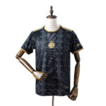 Black patterned sports jersey with gold trim on collar and sleeves, displayed on a mannequin; features a gold sun emblem at center.