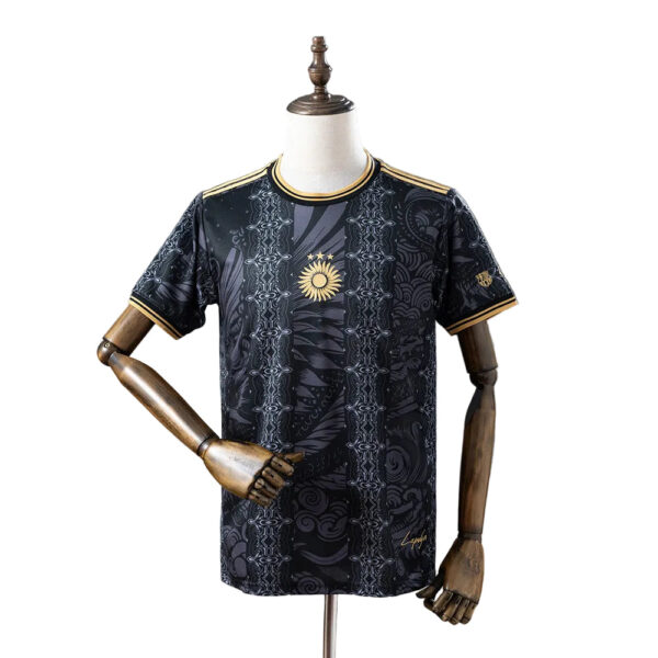 Black patterned sports jersey with gold trim on collar and sleeves, displayed on a mannequin; features a gold sun emblem at center.
