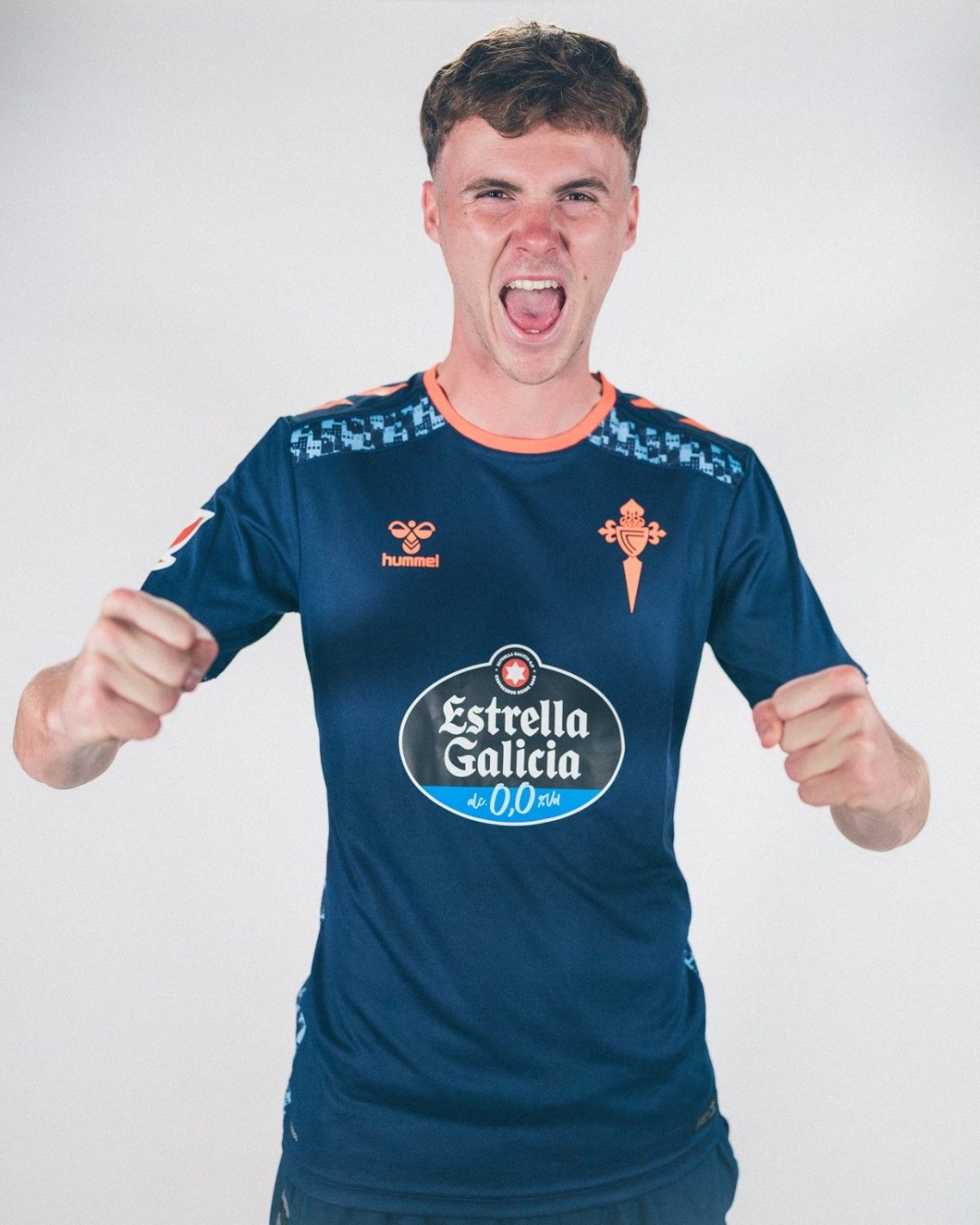 Young man in a blue sports jersey shouting with fists raised in celebration.