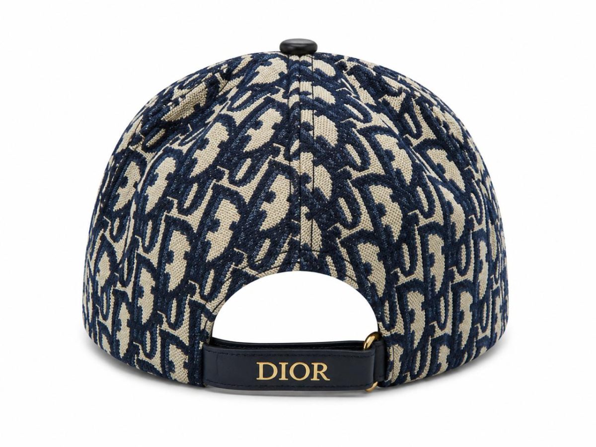 Back view of a navy and beige patterned Dior baseball cap with an adjustable strap showing the gold 'DIOR' lettering.