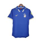 Blue soccer jersey on a hanger with a yellow Nike swoosh and an Italian crest on the left chest.