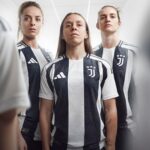 fwwjGGRsUWX7xak | UAE SPORT STORE Three female soccer players in black-and-white Juventus jerseys stand in a corridor, looking serious at the camera.