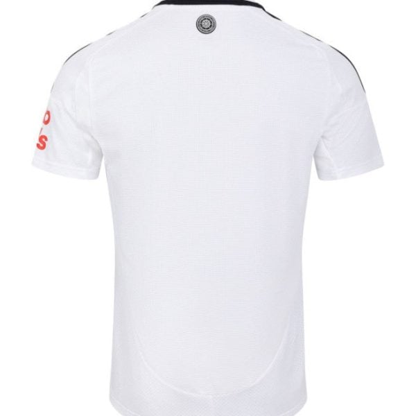 Back view of a white polo shirt with a small circular logo at the neck and red text on the left sleeve.
