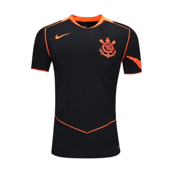 Front view of a black soccer jersey with orange piping and a crest on the left chest.