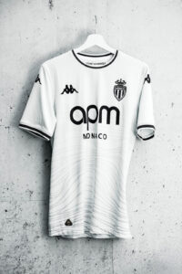 White AS Monaco football jersey on a hanger, with Kappa logos on sleeves and the sponsor 'apm MONACO' across the chest.