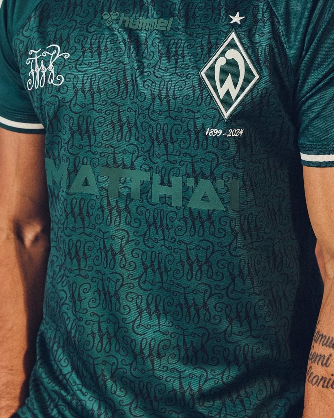 gyAqhs1ASwnsou7 | UAE SPORT STORE Teal football jersey with an ornate dark pattern, club crest on the left chest and 'MATHEI' across the front.