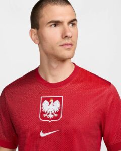 Portrait of a man in a red Poland national football team jersey with a white eagle crest and Nike logo','Close-up of a man wearing a red Poland soccer jersey featuring the white eagle emblem.