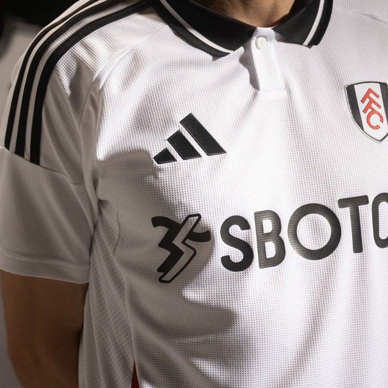 hDdvLMnsQAH5Eti | UAE SPORT STORE Close-up of a white soccer jersey with Adidas logo and SBOTOP sponsor, partial club crest on the chest.
