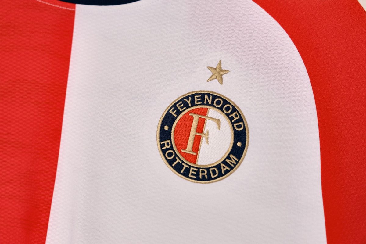 Feyenoord Rotterdam football club crest on a red‑and‑white striped jersey with a gold star above the badge.