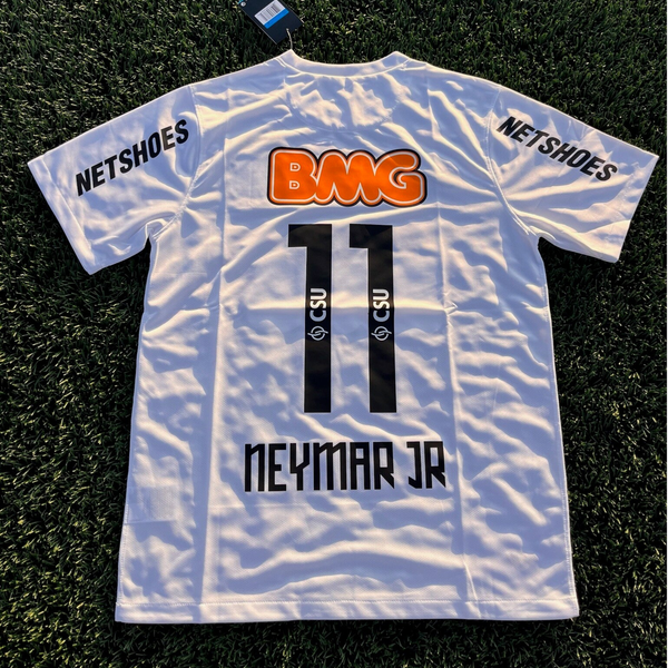 White soccer jersey on grass, back view with Neymar Jr. 11 in black, orange BMG logo, and NETSHOES text on the sleeves.