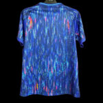 Blue athletic T-shirt with neon teal, pink, and yellow abstract streak pattern on a black background.