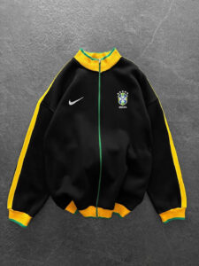 Black Brazil national team track jacket with yellow sleeves, green zipper, and crest on the left chest.