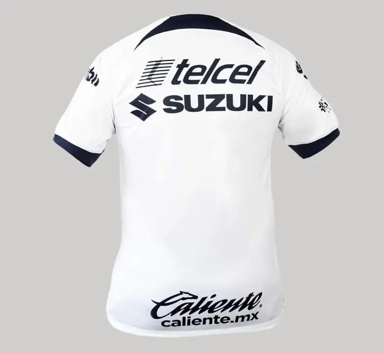 img_0304_jpg_a132a29f-e33e-4bae-93a2-2ffa79856c3d | UAE SPORT STORE Rear view of a white sports jersey with navy accents and sponsor logos (telcel, SUZUKI) on the back and Caliente.mx at the lower back edge.