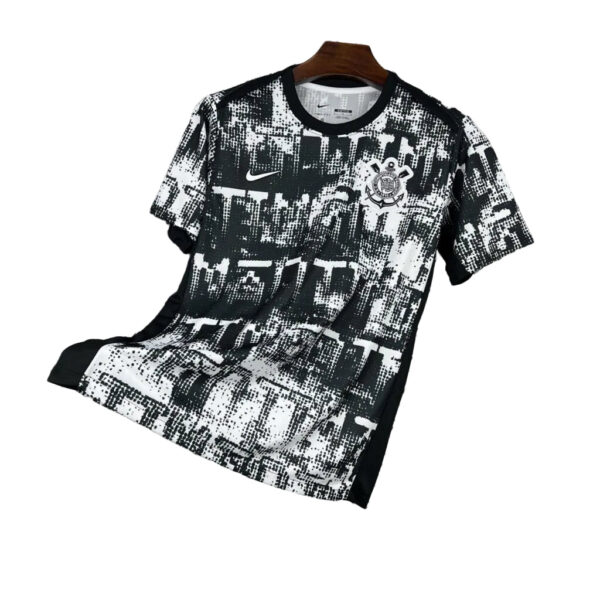Black and white abstract-pattern soccer jersey on a hanger, featuring a Nike swoosh and a circular club crest on the chest.