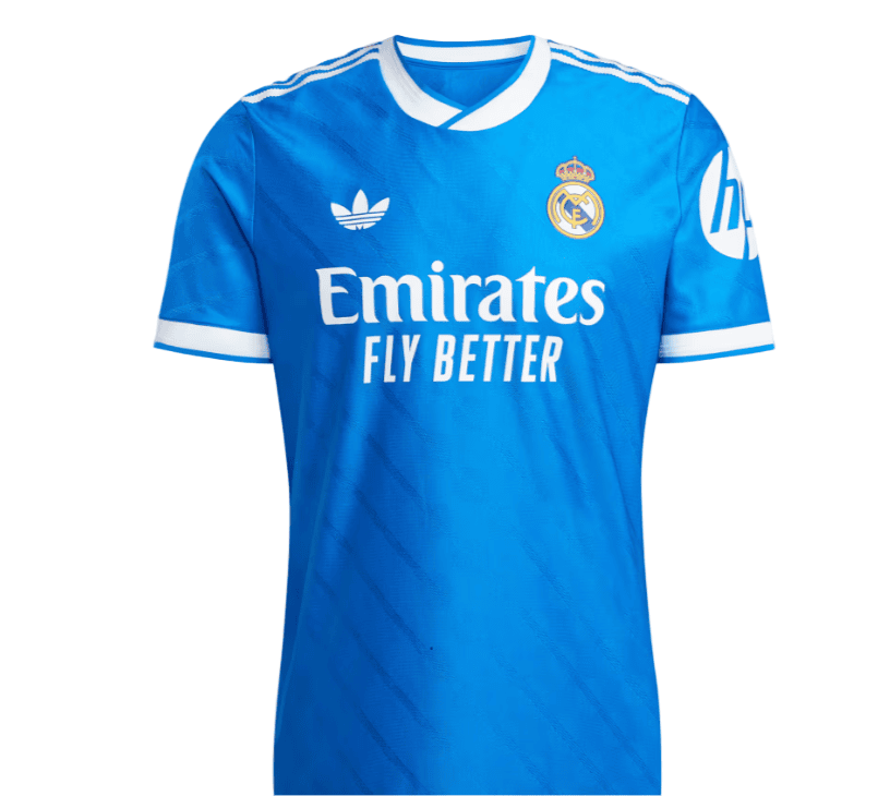 io | UAE SPORT STORE Blue Real Madrid football jersey with crest and 'Emirates Fly Better' sponsor text on the front.