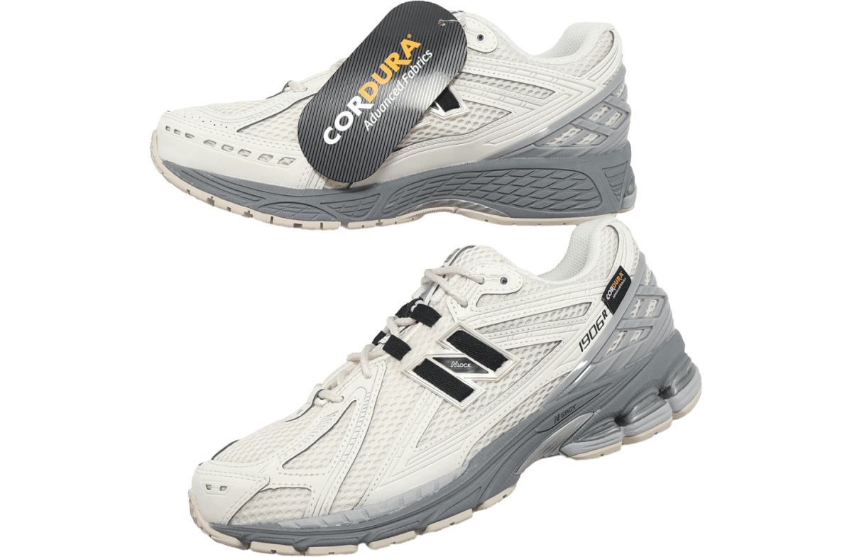 Pair of white and gray running shoes shown at angles, with a black CORDURA tag attached to the top shoe's laces tag.