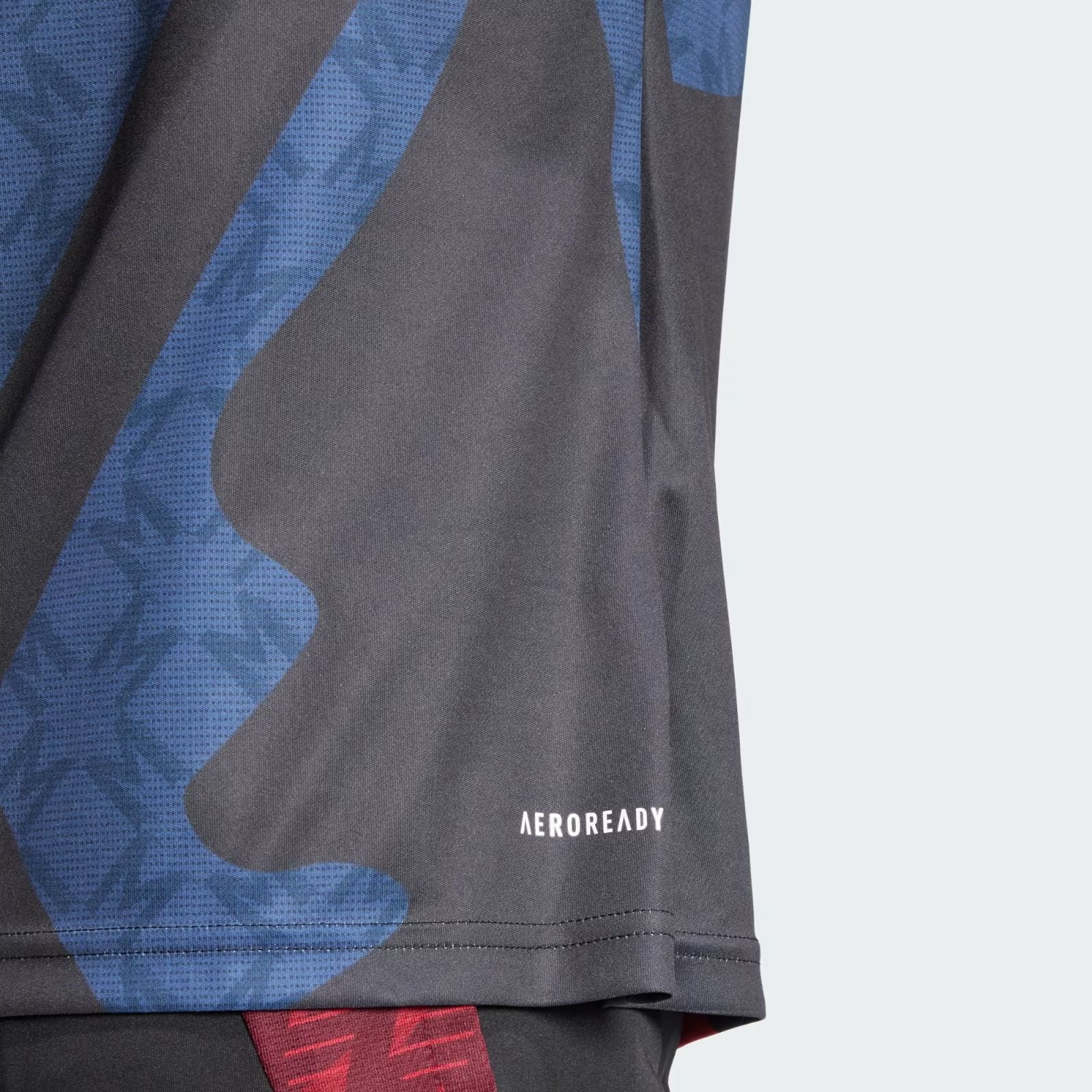 j1lJrkcKVd3EH8o | UAE SPORT STORE Close-up of blue and black camouflage athletic fabric with 'AEROREADY' branding visible on the hem edge