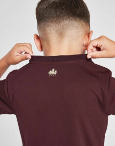 Back view of a person wearing a maroon textured shirt, with a small ship emblem on the upper back near the collar.