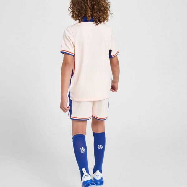 Child wearing a light pink soccer kit with blue and orange trim, viewed from behind.