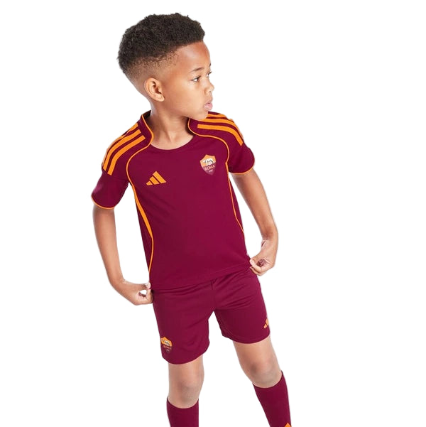 Young boy wearing maroon AS Roma soccer kit with orange accents, standing with hands on hips and looking to the right.