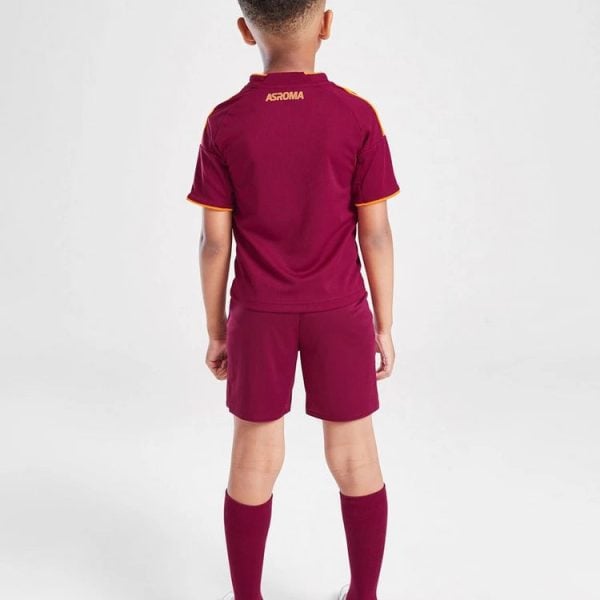 Back view of a child in a maroon AS Roma soccer kit (shirt, shorts, long socks) with white sneakers.