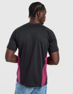 Man wearing a black T-shirt with magenta side panels, viewed from the back, paired with blue jeans.