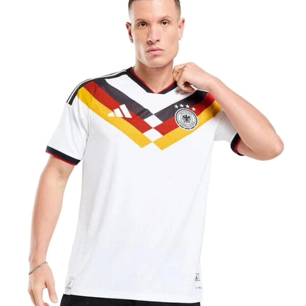 Male model wearing a white Germany national team soccer jersey with black-red-gold chevron pattern and crest on the chest.