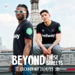 Two West Ham players pose on a rooftop in the 2024/25 Cockney kit, with bold promo text 'BEYOND THESE STREETS'.