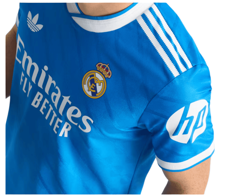 k | UAE SPORT STORE Blue Real Madrid football jersey with Emirates Fly Better sponsor, club crest, Adidas stripes, and HP logo on the sleeve.