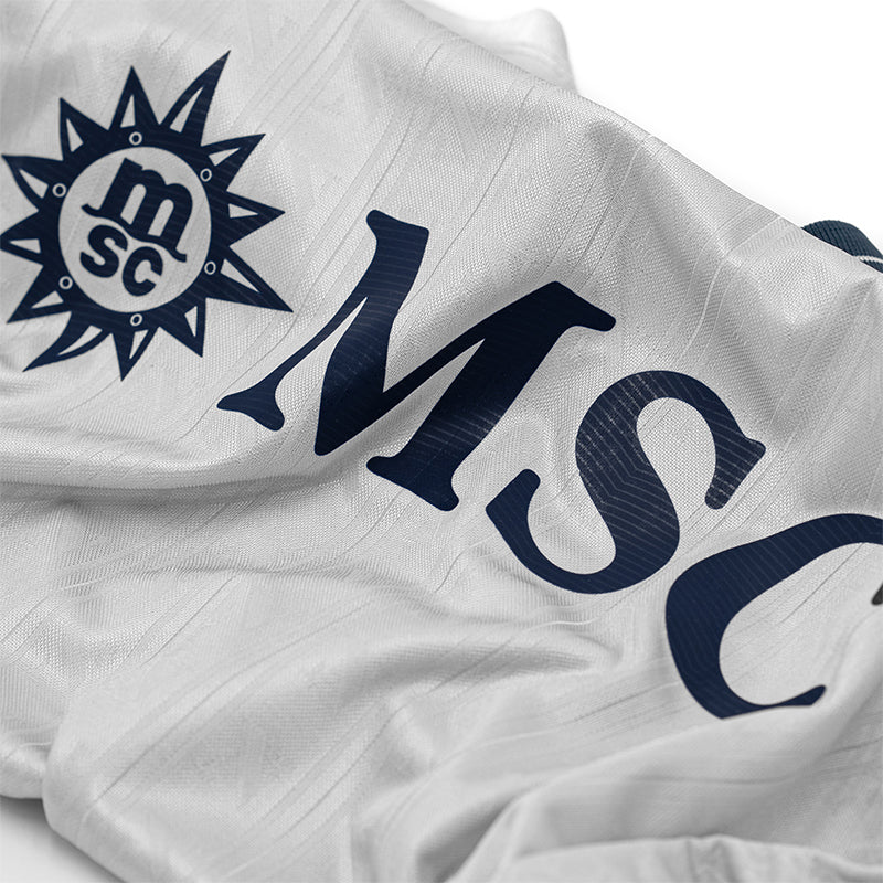 kd_d5de8ea9-1fc5-42ff-8dde-ae4a1b69fd9f | UAE SPORT STORE Close-up of white fabric featuring a navy MSC logo and large 'MSC' lettering.