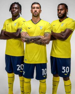 Three male soccer players in yellow Lazio jerseys pose with arms crossed