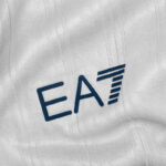 kv | UAE SPORT STORE Blue EAT logo on white textured fabric, letters E A T with a stylized striped T.
