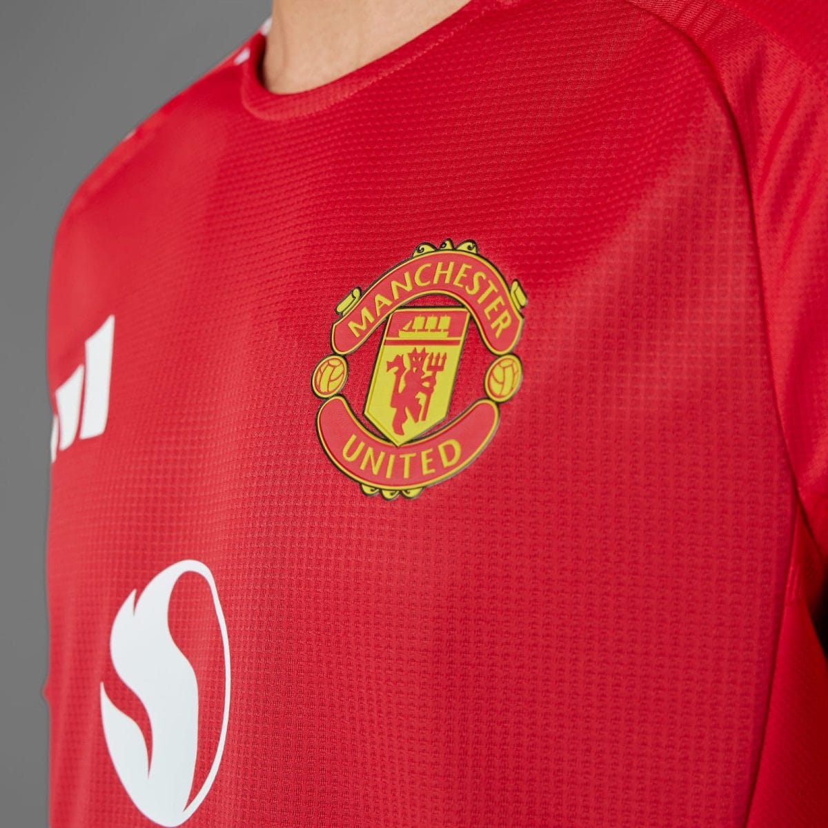 Manchester United crest on a red jersey.