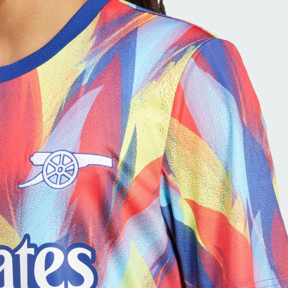 Close-up of a vibrant, multicolored sports jersey with an Arsenal cannon crest visible on the chest area.