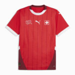Red football jersey with white-trimmed sleeves and collar, featuring Swiss flag badge, Puma logo, and vertical stripes (Swiss national team kit).
