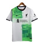 Liverpool FC jersey with white and neon green geometric panels, featuring the crest and Standard Chartered sponsor on the front.