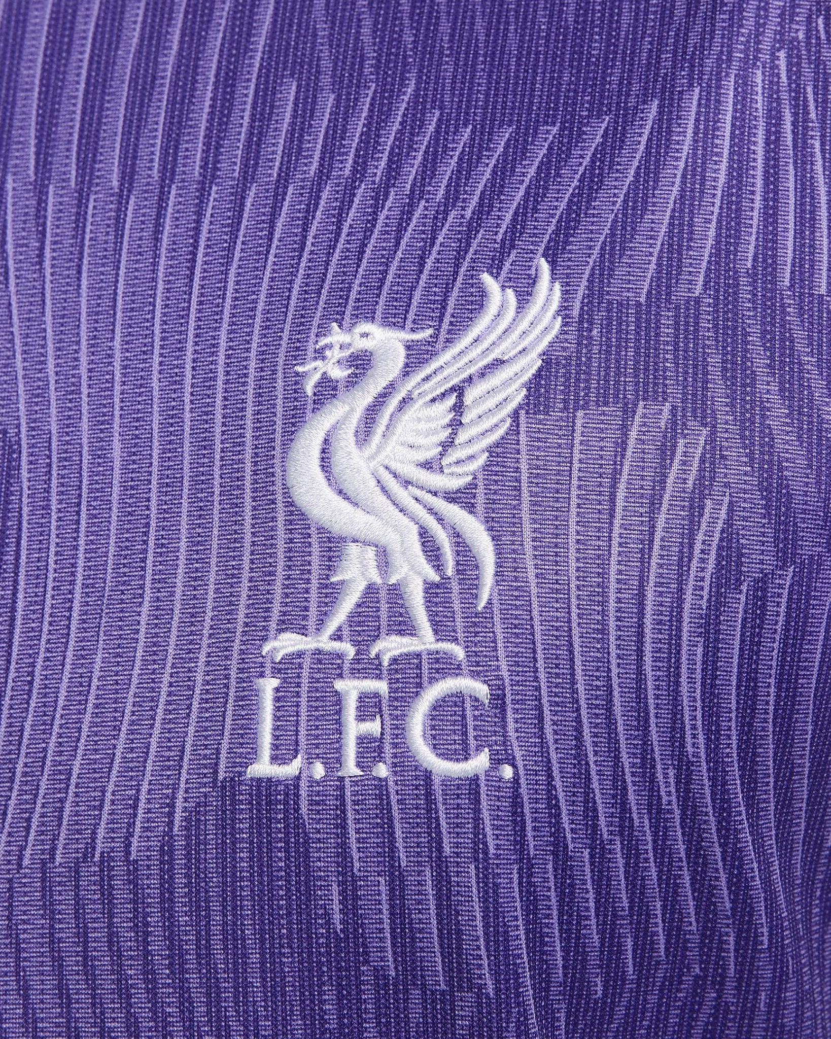 liverpool-third-jersey-202324-217297_279ea97d-ab6e-4e24-b414-5a6fff104e27 | UAE SPORT STORE Close-up of white Liverpool FC Liverbird emblem embroidered on purple striped fabric (jersey)
