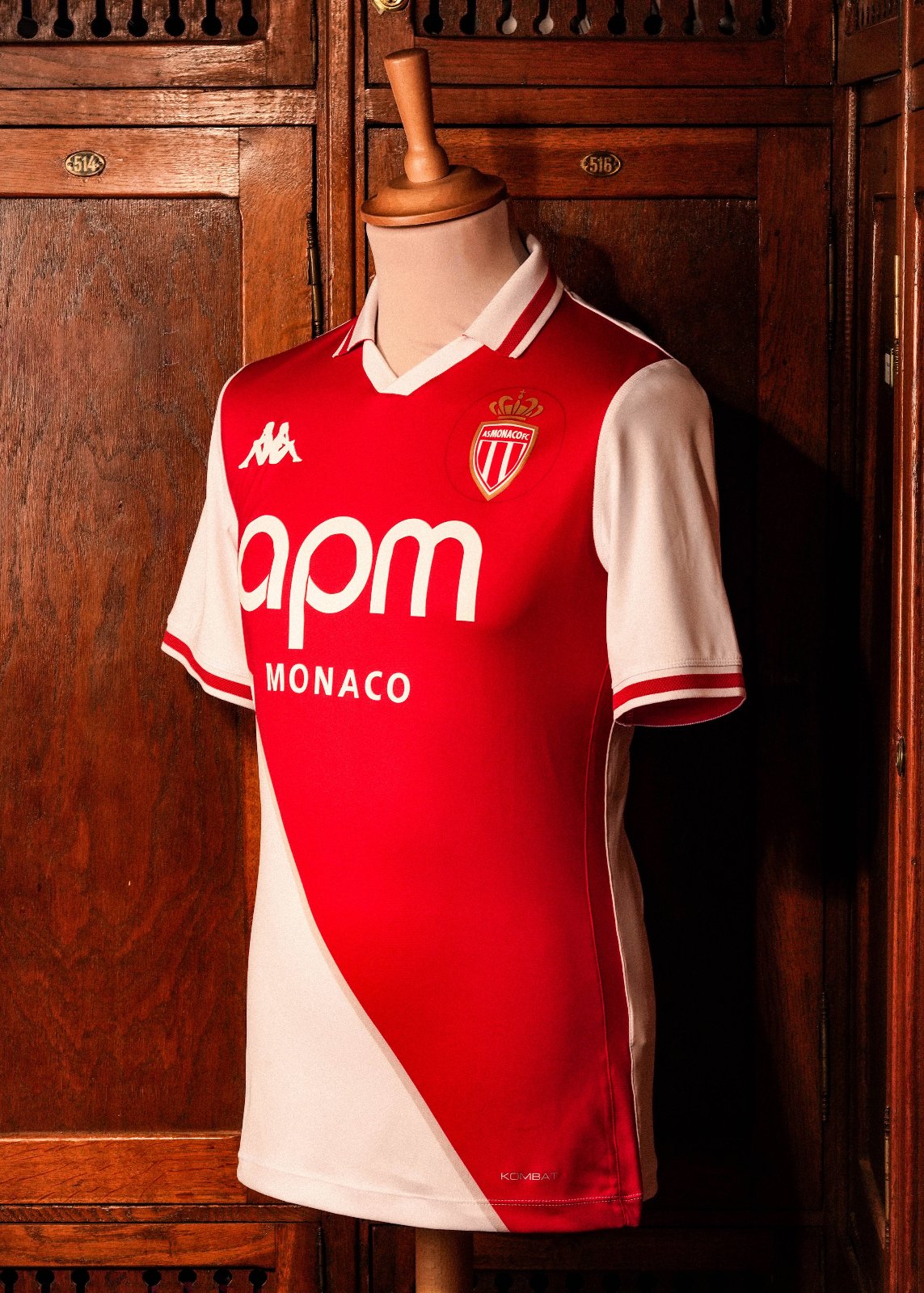 lmb8PjKUYubQeEA | UAE SPORT STORE Red AS Monaco football jersey on a dress form, with Kappa logo and sponsor 'apm MONACO' displayed, set against wooden lockers.