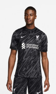 lsTWVEe91IfKWoX_84af4001-7aa0-4c66-8a56-3cceceead85b | UAE SPORT STORE Male model wearing a black camouflage Liverpool FC away jersey with Nike swoosh and Standard Chartered sponsor.
