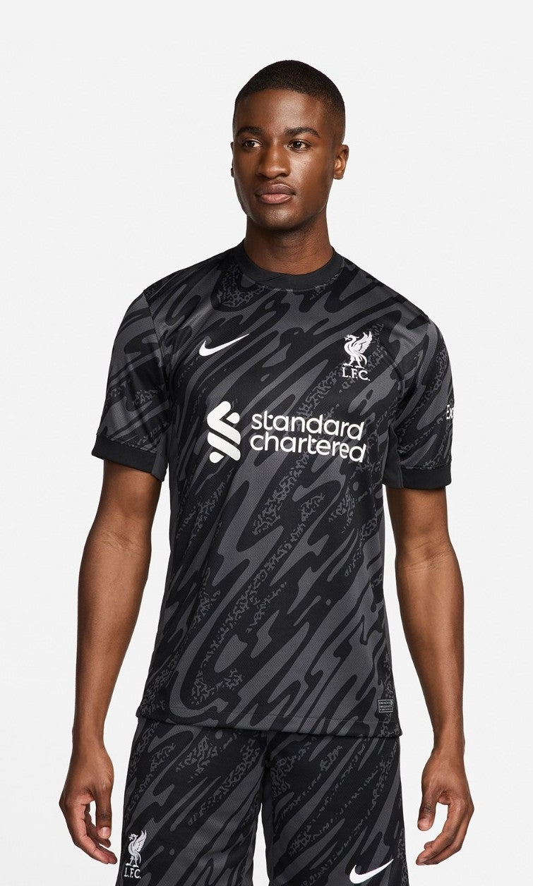 lsTWVEe91IfKWoX_84af4001-7aa0-4c66-8a56-3cceceead85b | UAE SPORT STORE Male model wearing a black camouflage Liverpool FC away jersey with Nike swoosh and Standard Chartered sponsor.