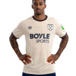 Male athlete standing with hands on hips, wearing a cream West Ham United rugby/football jersey with Boyle Sports sponsor logo.