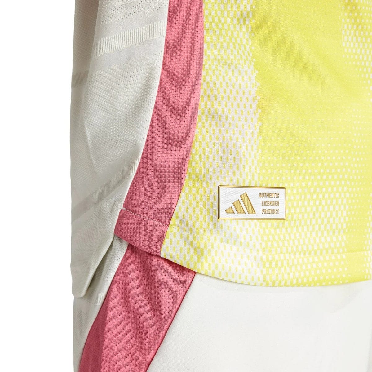 Close-up of a neon yellow and pink sports jersey fabric with a small Authentic Licensed Product patch.