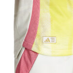 Close-up of a neon yellow and pink sports jersey fabric with a small Authentic Licensed Product patch.