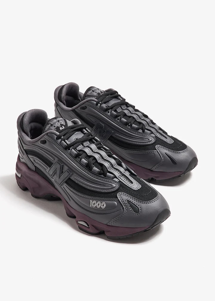 m1000eb-052_7 | UAE SPORT STORE Pair of dark gray chunky sneakers with black laces and maroon soles on a white background.