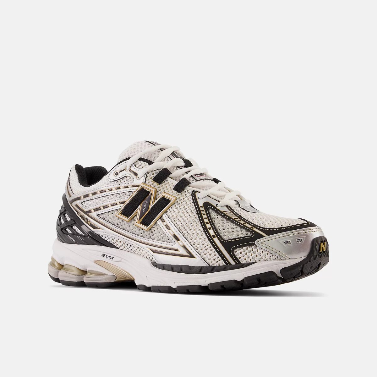 White and black running sneaker with gold accents, mesh upper and thick sole, side view showing the 'N' logo.