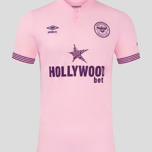 Pink football jersey with crest on left chest, Umbro logo on right, star graphic and 'HOLLYWOODbet' sponsor across the front; striped sleeve cuffs.