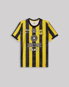 Yellow and black striped soccer jersey with multiple logos, including a Nike swoosh, a circular emblem, and Arabic text.