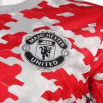 man-utd-21-22-pre-match-shirt-crest_91a967a5-236b-4768-9749-720d71a5d0ac | UAE SPORT STORE Manchester United crest patch on a red and white camouflage jacket.